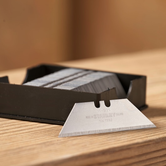 STANLEY 11-921 utility blades with dispenser, one silver blade in front, close-up product photography.