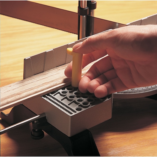 STANLEY 20-800 miter box photography, close-up of hand positioning yellow peg for wood cutting.