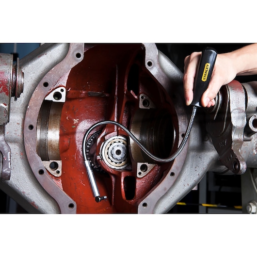 Photo of STANLEY 78-020 flexible magnetic pickup tool being used to retrieve small parts from machinery.