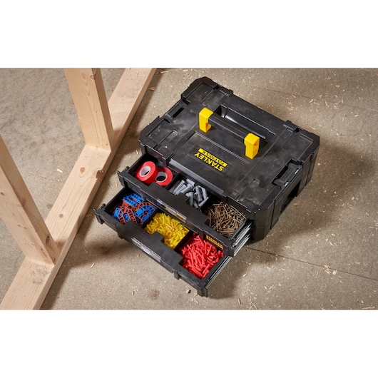 STANLEY FMST1-71969 black organizer box with open drawers showing assorted hardware, angled top view.