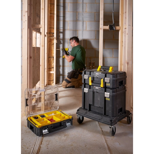 STANLEY FMST1-71971 rolling toolbox stack with yellow handles used at a construction site, open organizer with compartments.