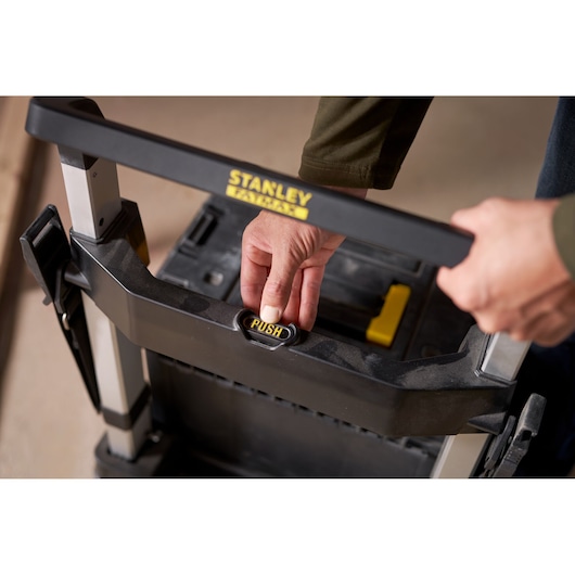 Photo of STANLEY FMST1-72363 toolbox handle being pushed, showing durable black handle and yellow branding.