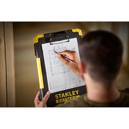 STANLEY FMST82721-1 clipboard with yellow handle, held by person marking architectural plan.