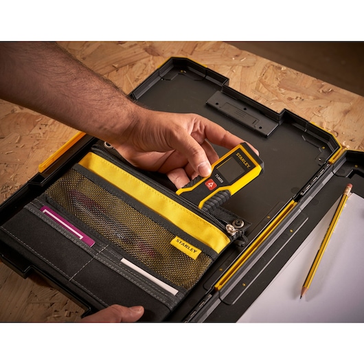 Photo of STANLEY FMST82721-1 tool case with yellow and black organizer, hand holding digital measuring tool.