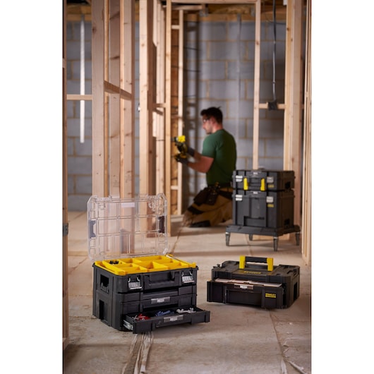 STANLEY FMST82967-1 modular toolboxes with yellow accents and clear lid, shown open on a construction site.