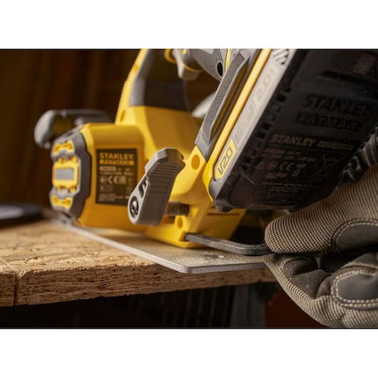 STANLEY SBC550D1K cordless circular saw cutting wood, close-up angle, black and yellow design.
