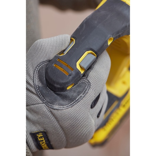Photo of a gloved hand gripping the handle of a STANLEY SBH900 power tool, showing black and yellow design details.