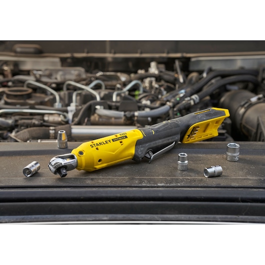 STANLEY SCF930B cordless ratchet tool on car engine with socket attachments, yellow and black design.