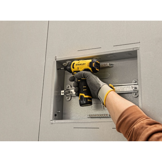 Photo of STANLEY SCI10 cordless screwdriver used to install screws in a metal electrical box.