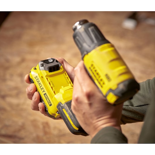 STANLEY SCX530B-B3 cordless drill and battery, yellow and black, held in hand, close-up photography.