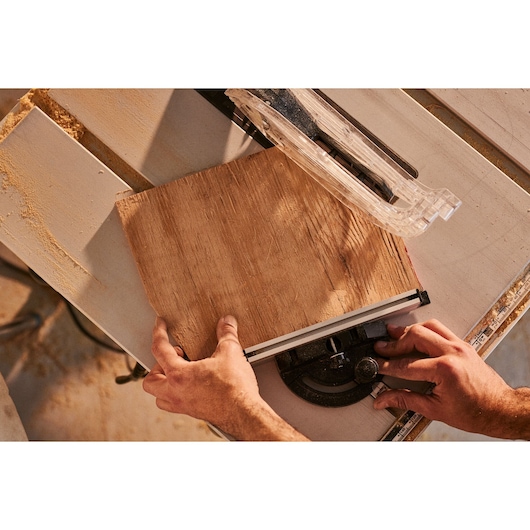 STANLEY SST2001-B2 table saw in use, cutting a wooden board, top view in workshop.