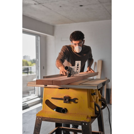 STANLEY SST2001-B2 table saw in use, cutting wood in a workshop setting, photographed from the front.