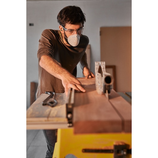 STANLEY SST2001-B2 table saw in use, close-up side view, cutting wood in workshop setting.
