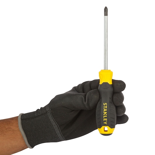 STANLEY STMT60809-840 Phillips screwdriver with yellow and black handle held in gloved hand, side view.