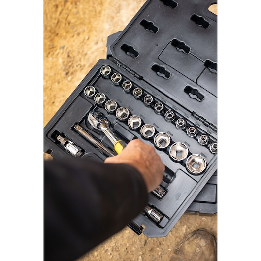 STANLEY STMT82830-LA socket set in black case, hand holding ratchet, top view, tool kit photography.