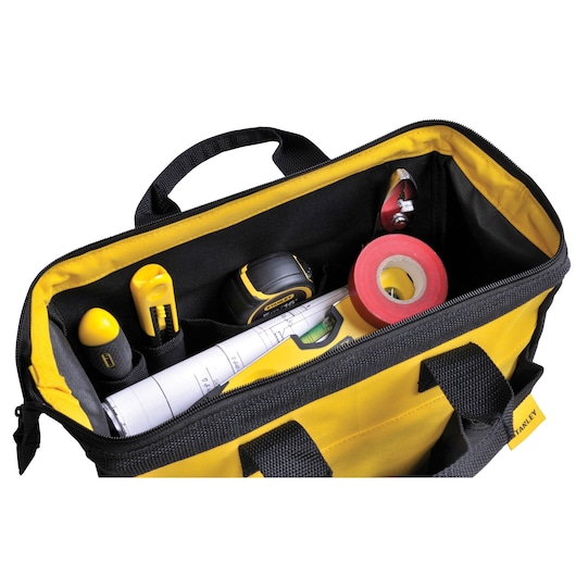 STANLEY STST512114 tool bag top view with yellow and black fabric, containing tools, tape, and rolled plans.